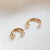 Piercing Ferradura Smile com pedras de zircônia cravejadas, folheado a ouro e feito em aço cirúrgico. Elegante, resistente e hipoalergênico.

