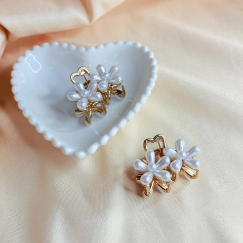 Piranha de cabelo pequena em metal, com design de flores duplas de pérola. Ideal para prender mechas e dar um toque sofisticado ao penteado.