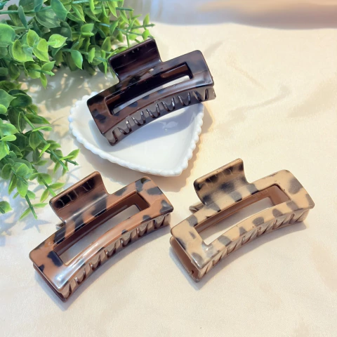 Piranha de cabelo em formato retangular com estampa animal print marrom, feita em acrílico resistente. Ideal para prender mechas ou todo o cabelo com estilo e segurança.