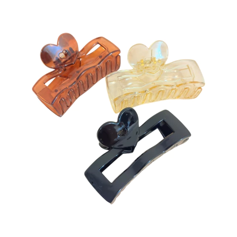Presilha piranha de cabelo retangular com design de coração no topo, material transparente em várias cores. Ideal para prender mechas grandes e coques maiores.