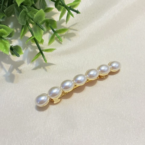 Presilha de cabelo com fivela dourada e pérolas ovais, perfeita para penteados do dia a dia ou ocasiões especiais.