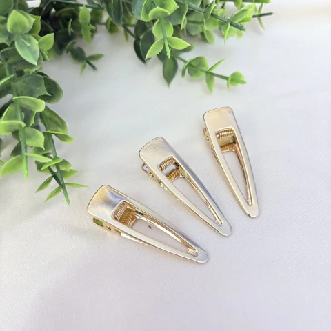 Kit com 3 presilhas Finger Tips douradas de metal, com design moderno e abertura central. Acessório elegante e prático para o dia a dia. Pistache Acessórios.