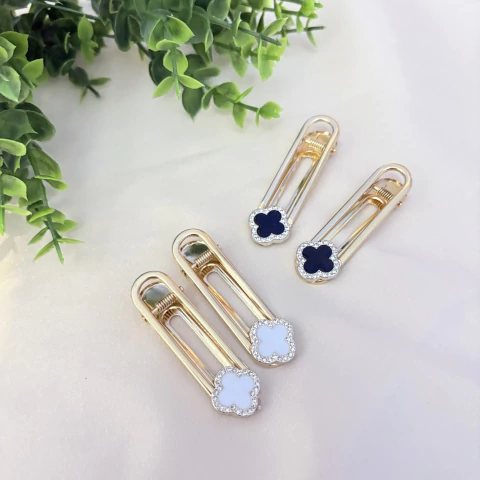 Presilha Finger Tips dourada com trevo central rodeado por pedras de strass. Acessório elegante e delicado para iluminar seus penteados. Pistache Acessórios.

