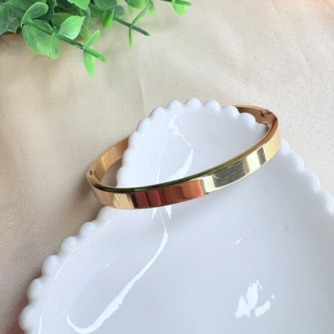 Pulseira bracelete dourada lisa com fecho de encaixe, feita em aço inox de alta qualidade. Um acessório resistente, elegante e ideal para o dia a dia ou ocasiões especiais.