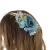 Faixa de cabelo com flores silvestres coloridas, incluindo rosas em tons claros e detalhes em verde e branco.