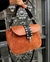 Cartera de cuero con manija y tachas