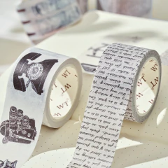 Cintas washi decorativas, una con ilustraciones vintage en blanco y negro, de teléfono antiguo y máquina fotográfica y otra con textos manuscrito en fondo gris claro