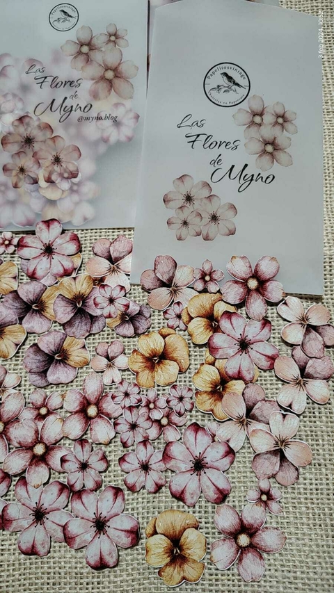 Die cuts de flores vintage en tonos rosa, lila y amarillo sobre fondo de arpillera, con dos sobres que incluyen la marca "Las Flores de Myno".