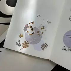 Stickers Pion con ilustraciones de flores aplicados en un cuaderno abierto