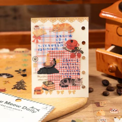 Plancha de stickers transparente con ilustraciones de gatos durmiendo, libros, vela y utensilios de cocina sobre fondo con diseño a cuadros y texto en japonés y inglés