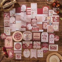 Set de papeles decorativos para journaling con diseño floral y tonos rosas y rojos sobre mesa de madera