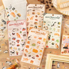Set de 4 planchas de stickers Meow Meow Daily con diseños de gatos y elementos temáticos como café, plantas, comida y objetos cotidianos sobre una mesa de madera