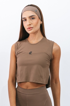 Modelo usando regata cropped flow marrone da Lurk, com cabelo liso e faixa na cabeça.