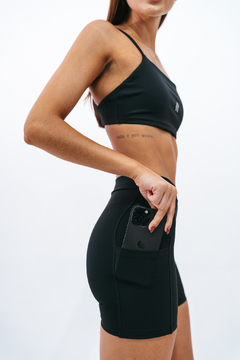 Modelo usando shorts slim preto da Lurk, destacando o bolso com um celular.