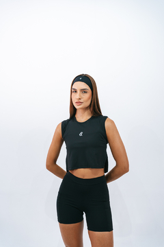 Modelo usando uma regata cropped preta da marca Lurk, com cabelo liso e preso, em um fundo branco.