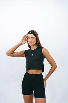 Modelo feminina usando uma regata cropped preta da marca Lurk, com cabelo solto e faixa na cabeça, posando de forma confiante.