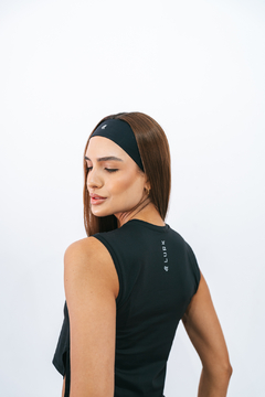 Mulher usando uma faixa de cabelo preta da marca Lurk, com olhar suave e cabelo liso, vista de costas.