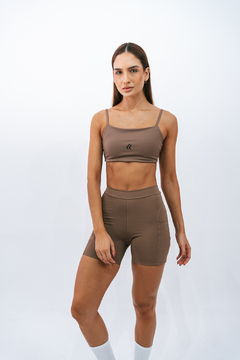 Modelo vestindo um top slim marrone da Lurk, posando com um fundo branco.
