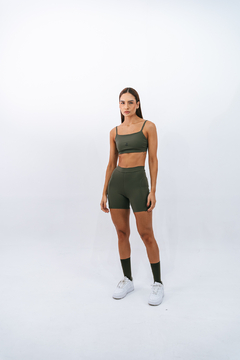 Modelo feminina usando top slim e shorts na cor verde-oliva, em um fundo branco.