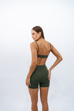 Modelo feminina usando o Top Slim Major Lurk na cor verde, visto de costas, com short curto combinando.