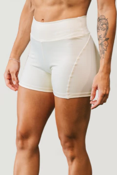 Shorts brancos de alta cintura, parte de um conjunto feminino da marca Lurk, destacando a modelagem e o design.