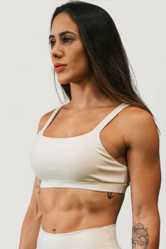 Modelo usando um conjunto feminino em tom neutro da marca Lurk, destacando a parte superior do conjunto.