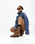 Modelo luciendo una texana marrón, combinada con una chaqueta de jean y gafas de sol, posando en un fondo blanco.