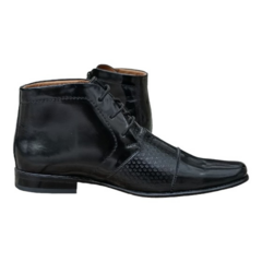 Botines de cuero negro con detalles en relieve y cierre de cordones.