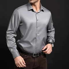 Hombre vistiendo una camisa slim fit de seda gris oscuro con fondo negro.