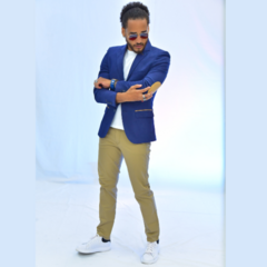 Hombre con blazer azul oscuro y coderas, usando pantalones beige y zapatillas blancas, posando con actitud.