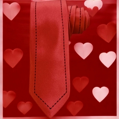 Corbata roja con patrón de doble línea negra, presentada sobre un fondo rojo con corazones.