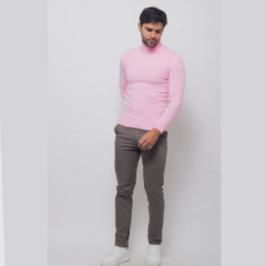 Buzo cuello tortuga de color rosa, ajustado, combinado con pantalones gris oscuro y zapatillas blancas, modelo posando de pie.