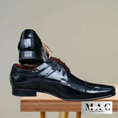 Zapatos Riviera de cuero negro, con un diseño elegante y brillante, mostrados desde un ángulo lateral.