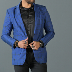 Hombre usando un blazer premium de cuadros slim fit en color azul, con una camisa negra y accesorios de joyería.