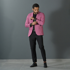 Hombre vistiendo un blazer premium slim fit de color rosa viejo, ajustándose la muñeca de su camisa.