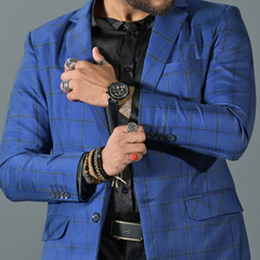 Hombre vistiendo un blazer premium azul con cuadros, mostrando su estilo y accesorios.