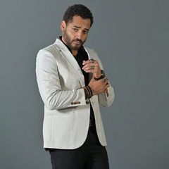 Hombre posando con un blazer premium slim fit color tiza, combinado con una camisa negra.