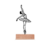 Escultura de parede representando uma bailarina em pose elegante, com base de madeira clara.