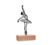 Escultura de parede representando uma bailarina em pose graciosa, com base de madeira.