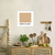 Quadro decorativo "Café Com Leite" em uma cozinha minimalista, com fundo claro e elementos como ervas, utensílios e alimentos.