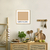 Quadro decorativo com a inscrição "Café com Leite" em uma cozinha minimalista, rodeado por utensílios e ingredientes.