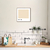 Quadro decorativo com a cor café latte, pendurado em uma cozinha moderna com armários brancos e plantas.