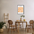 Quadro decorativo de Matisse com formas laranjas em um ambiente moderno, incluindo mesa e cadeiras de madeira.