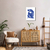 Quadro decorativo de uma mulher em azul, em um ambiente de sala de estar com móveis modernos.