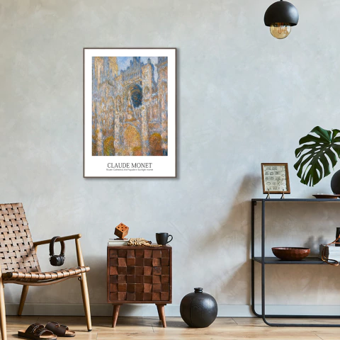 Quadro decorativo de Claude Monet mostrando a fachada da Catedral de Rouen em tempo nublado, em ambiente moderno com cadeira de madeira, mesa lateral e estante decorativa
