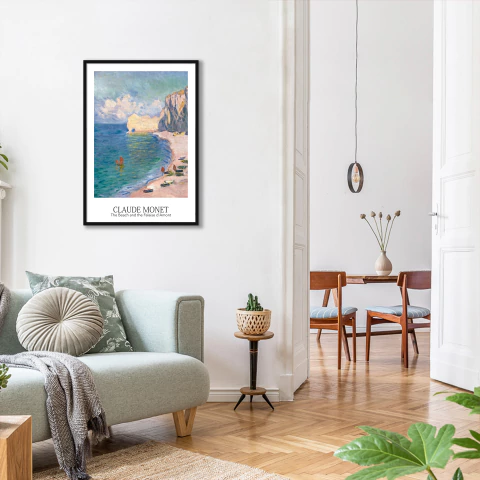 Quadro decorativo vertical com pintura de Claude Monet intitulada The Beach and the Falaise d'Amont, mostrando uma paisagem costeira com falésias, praia e mar, pendurado em sala de estar moderna com sofá claro e decoração minimalista.