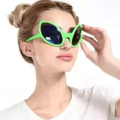 Anteojos verdes de estilo alienígena usados por una mujer.