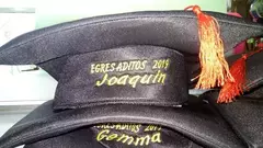 Birretes de egresado personalizados con bordados de nombres y año.