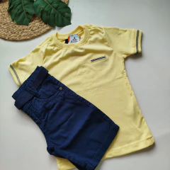 Conjunto camisa bolso falso amarelo e bermuda de cinto azul marinho.