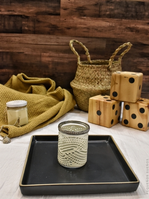 Portavelas de vidrio con borde de metal.